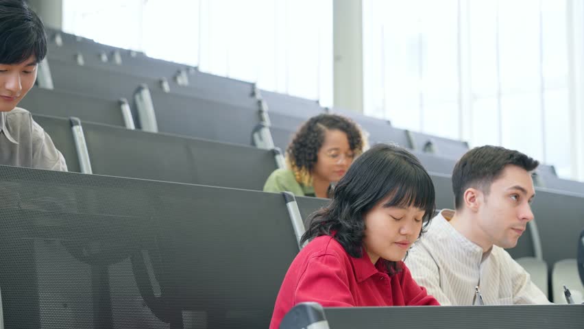 A group of multinational students taking a lecture in an auditorium. international education.