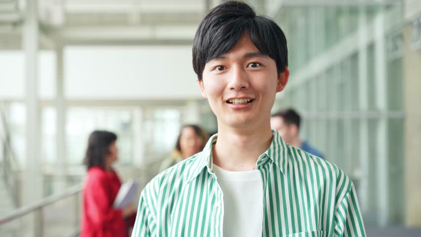 Casual Asian man smiling inside the building. University student.