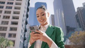 Young stylish elegant successful beautiful business woman using smart phone outside. Happy professional businesswoman executive holding cellphone modern tech standing at urban city street background - Powered by Shutterstock - Get 15% off with code: PIKWIZARD15