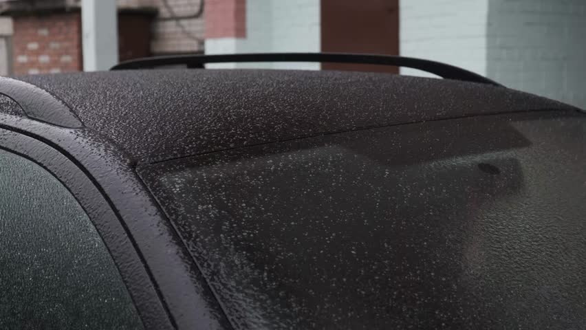 Wet snow and frost cause the car body and windshield to become covered with a layer of ice and snow. The car freezes in a parking lot on the street in winter.  | Shutterstock HD Video #1111738023