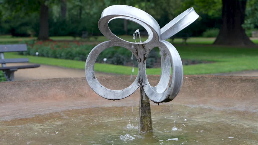 A small fountain on a European city street park close up
