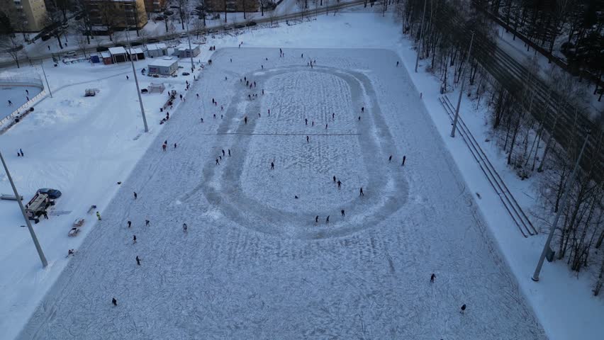 People ice-skating in Sorsapuisto, Tampere, Finland during a brisk winter day 