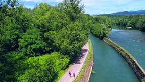 Trezzo sull'Adda, Italy. Aerial view of a mountain freshwater river with low water level surrounded by green trees. slaying. walks in the forest. Wild nature. Green Planet. Ecology. drone video