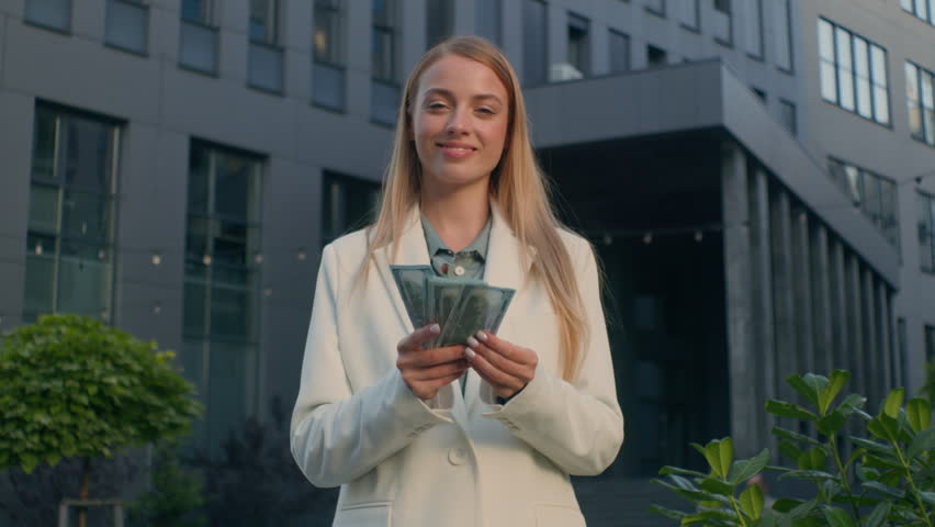 Happy smiling rich caucasian business woman girl businesswoman female winner manager entrepreneur holding cash outdoors near office building waving fan of banknotes money dollars salary profit finance | Shutterstock HD Video #1111751077