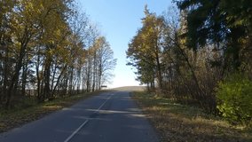 The car drives along the road on a autumn day. Highways, roadside and road line markings.