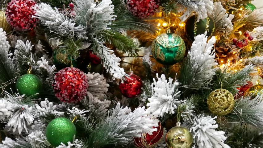 Close-up of a nice Christmas tree decorated with garland and many colorful Christmas balls