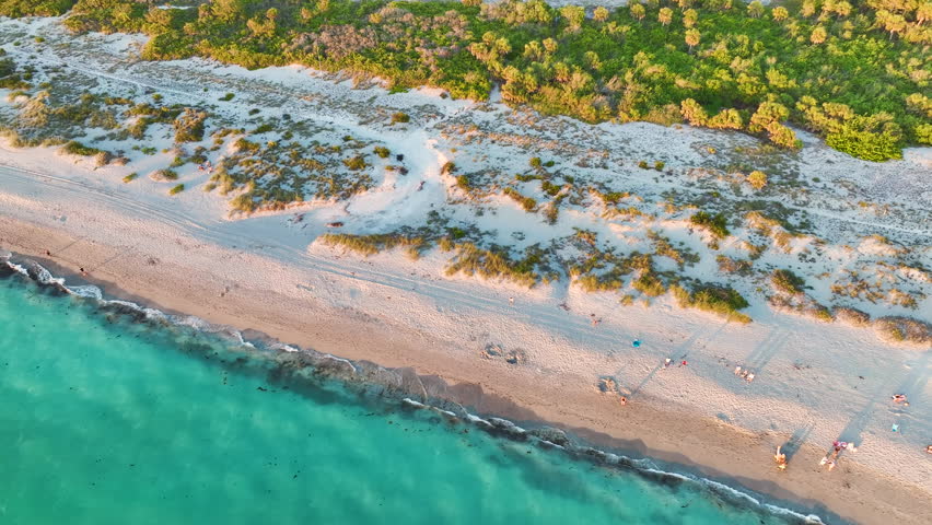 Aerial view of Blind Pass beach on Manasota Key, USA. Many people enjoying vacation time swimming in gulf water and relaxing on warm Florida sun at sunset