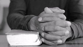 praying to God with hands on bible on table with people stock footage stock video