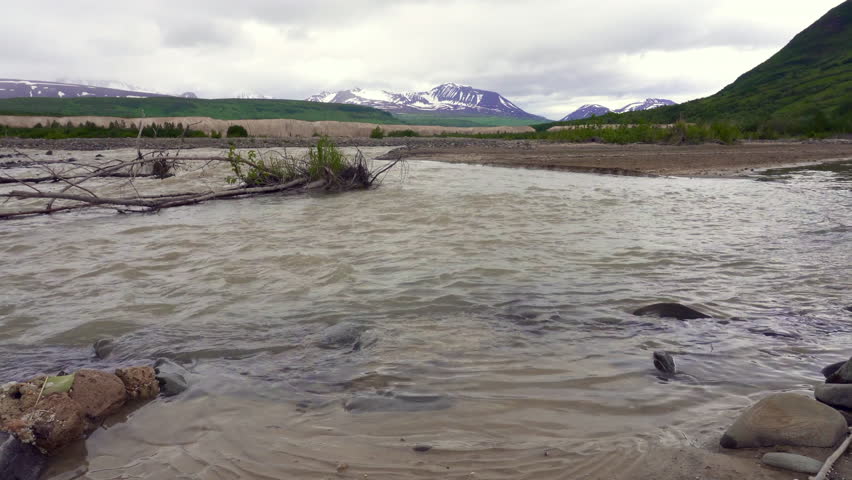 River flowing through The Valley of Ten Thousand Smokes in Katmai National Park and Preserve in Alaska. Valley between mountains is filled with ash flow from Novarupta eruption in 1912. Erosion of ash