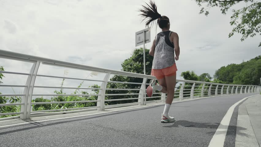 Rear view of young asian woman running jogging outdoors in park | Shutterstock HD Video #1111761005