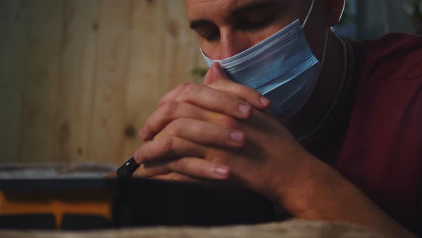 Asian man praying holy book with arms crossed. Man home during pandemic wearing medical mask of protection. safety on face. Man prays for health with hope. Medical mask protect against pandemic virus Royalty-Free Stock Footage #1111766485