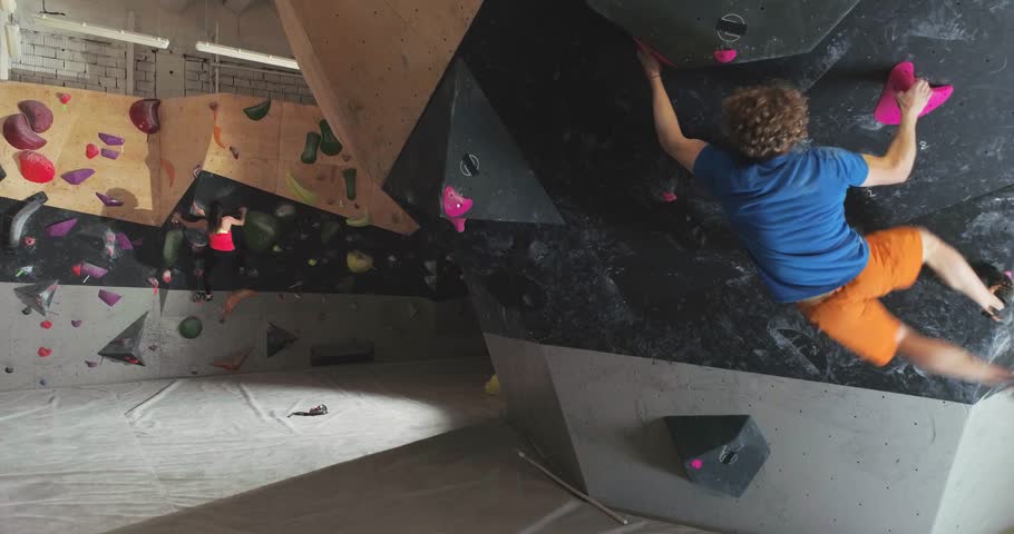 Sports, young climbers training on a climbing wall, woman and guy practicing rock-climbing and moving up, bouldering. | Shutterstock HD Video #1111769119