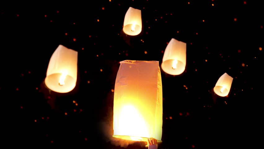 Hand releasing floating lantern to the night sky with many paper  lanterns floating at background for Yi Peng tradition during Loy Kratong Festival at Chiang Mai, North of Thailand | Shutterstock HD Video #1111770735
