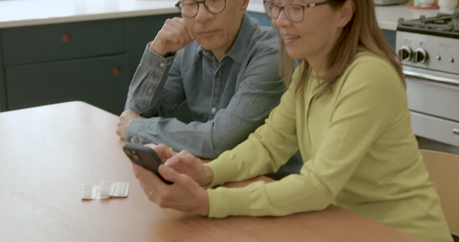 Senior Adult Couple Speaking to Doctor about Medication at Home using Smart phone | Shutterstock HD Video #1111773977