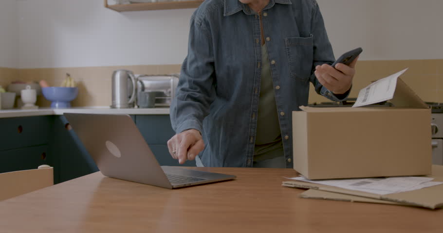 Senior Adult Female Entrepreneur in Kitchen using Smart phone | Shutterstock HD Video #1111773989