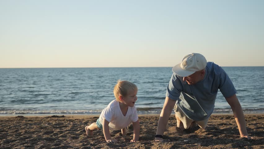 A young father goes in for sports with his 5-year-old son on a weekend at the beach. Dad teaches his son to do push-ups during sunset on the seashore. High quality 4k footage | Shutterstock HD Video #1111775701