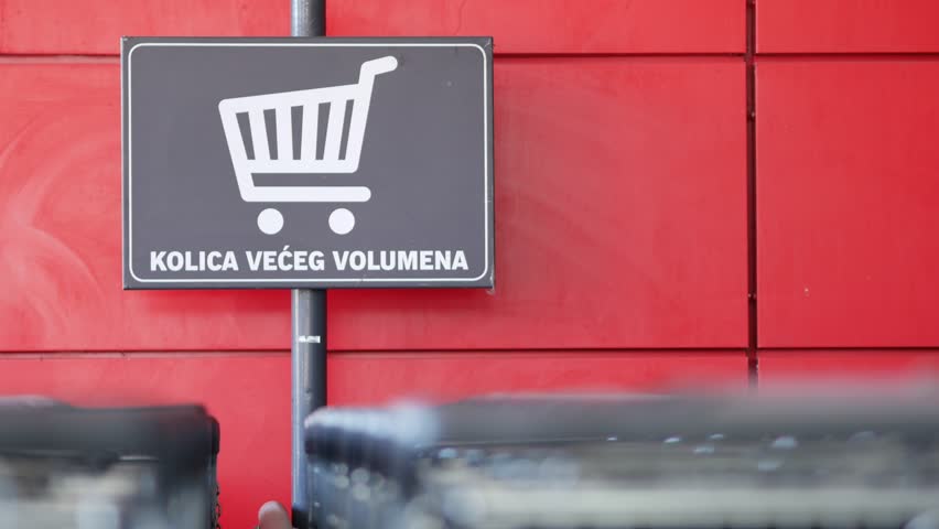 Grocery carts line up outside the store. Metal baskets on wheels for supermarket shoppers. A sign with the inscription - larger volume carts. Rovinj, Croatia - February 13, 2023 | Shutterstock HD Video #1111777357