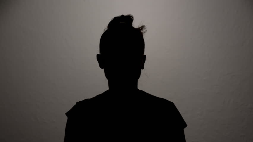 Hidden identity silhouette of woman talking anonymous interview looking at camera.