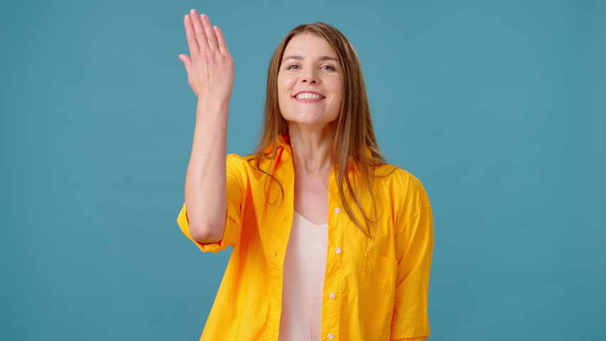 Charismatic woman expresses admiration for appearance of friend. Young female looks at pal with delight captivated by overall outfit in blue studio | Shutterstock HD Video #1111780675