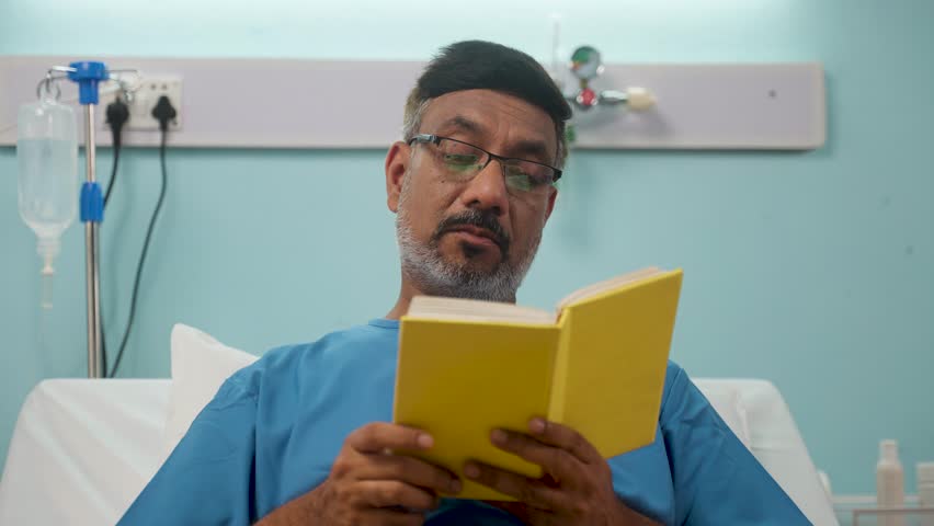 Indian elderly recovered man at hospital reading book at hospital bed - concept of relaxation, medical treatment and contemplation | Shutterstock HD Video #1111783105