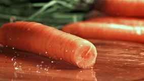 Knife cuts carrots with splashes. Filmed on a high-speed camera at 1000 fps. High quality FullHD footage