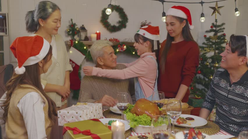 Asian kid hugging grandparent while celebrate Christmas party in house. Attractive family spending leisure free time on holiday vacation to celebrate Thanksgiving, X-mas eve on dining table at home. | Shutterstock HD Video #1111786647