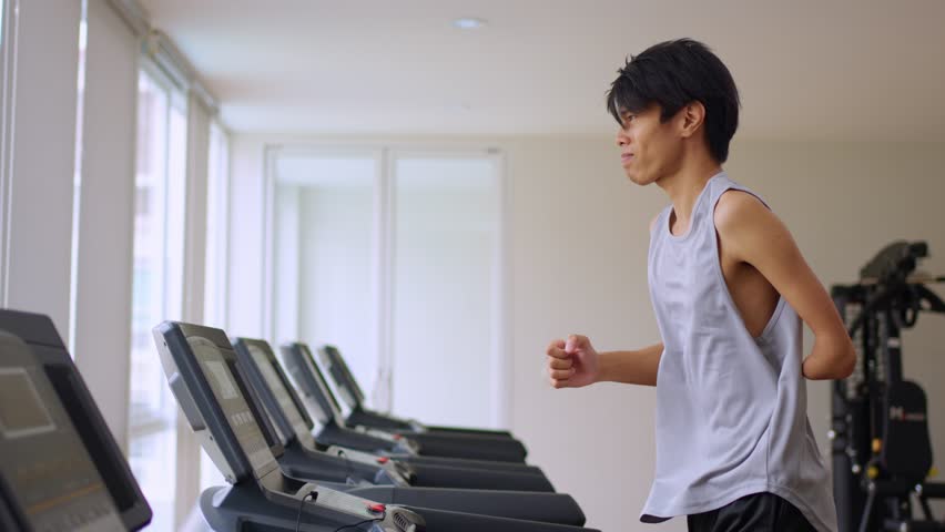 Asian young amputee without arm run on treadmill machine in fitness. Attractive happy sportsman athlete exercise and workout to maintain muscle for health care and wellbeing in gym stadium | Shutterstock HD Video #1111786697