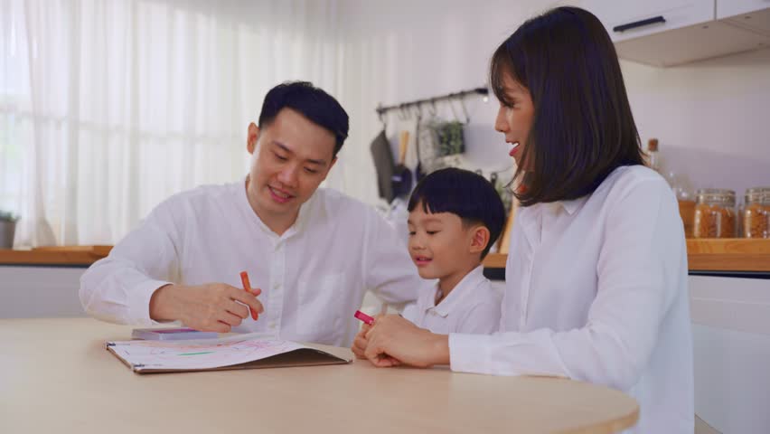 Adorable Asian young son draw picture on paper with parents in house. Happy family activity, Little baby boy children learn how to paint artwork enjoy creativity with mother and father in living room. | Shutterstock HD Video #1111786703