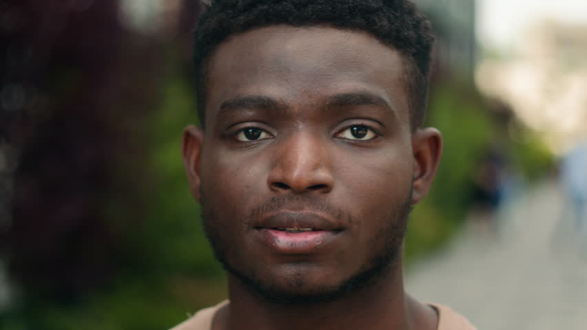 Close-up portrait of biracial calm guy African American male headshot serious pensive face young gen z concentrated ethnic man model handsome student outdoors in city posing at camera confident look | Shutterstock HD Video #1111789179