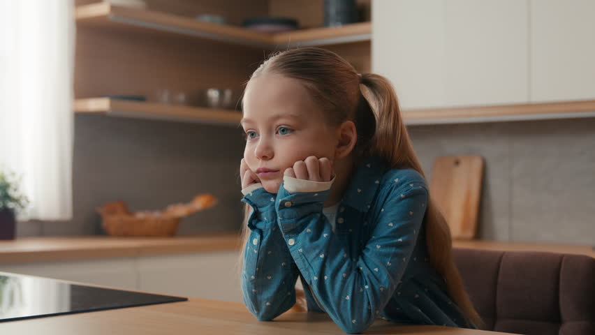 Moving camera sad little offended Caucasian child girl at kitchen boring stressed need parents help custody adoption family misunderstanding upset bored daughter unhappy lonely kid stress at home Royalty-Free Stock Footage #1111789199