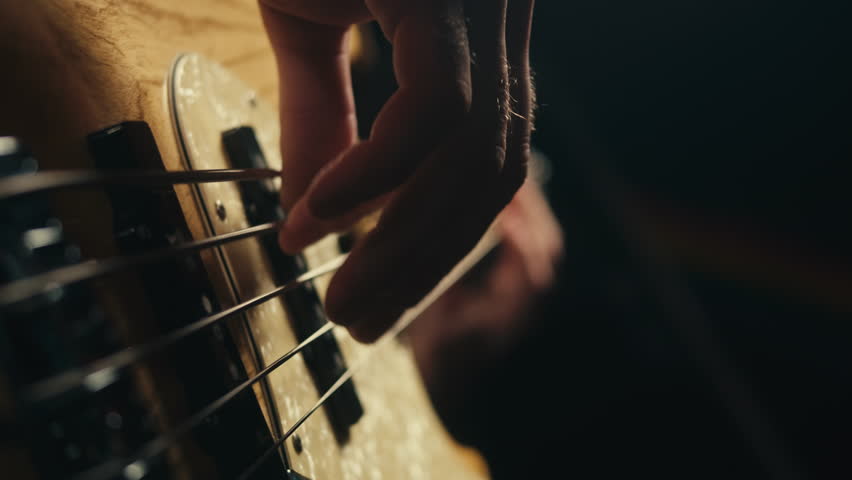 Young musician man sitting and playing the electric acoustic guitar among music equipment in studio close-up. Guitarist plays melody. Playing the chords. Solo concert, music repetition | Shutterstock HD Video #1111793967