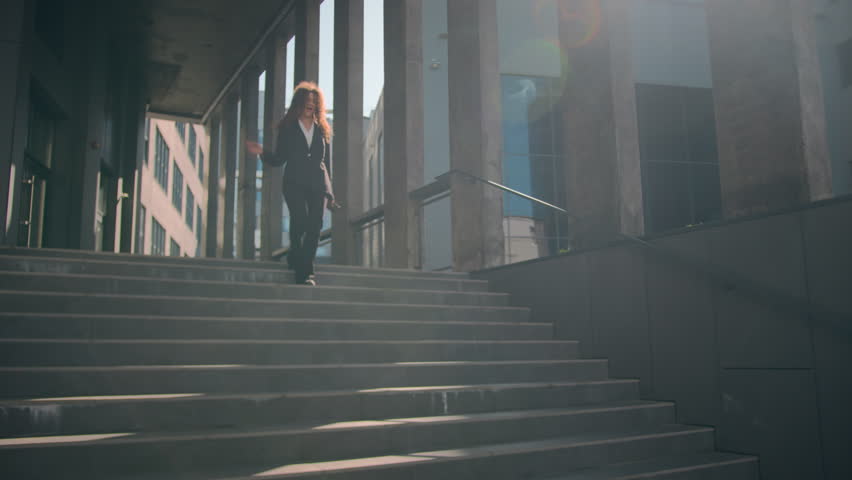 Caucasian happy carefree woman dancing in city sunlight joyful businesswoman female girl dance moving outdoors walking down stair of business company celebrate success having fun with music on phone | Shutterstock HD Video #1111797241