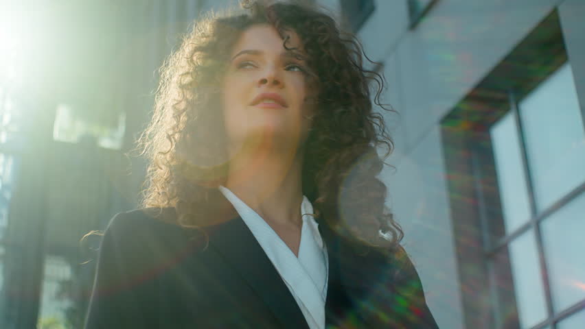 Portrait smiling business woman in golden sun shining outdoors happy gorgeous elegant young 20s Caucasian student businesswoman girl curly hair model female beauty in city sunbeams outside low angle | Shutterstock HD Video #1111797251