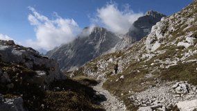Adult Woman Backpacker Hiking in Beautiful Sunny Day over European Alps - Kriski Podi Triglav national Park Slovenia