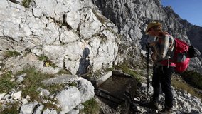 Adult Female Hiker Drinking Water from Alpine Spring in Hugh Mountains of European Alps - Kriski Podi, Julian Alps Slovenia