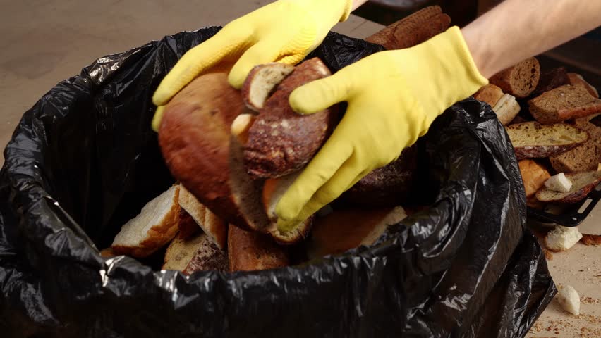 Baker throws unsold bread in the trash. Bakeries waste. Repurposing discarded dough | Shutterstock HD Video #1111800949
