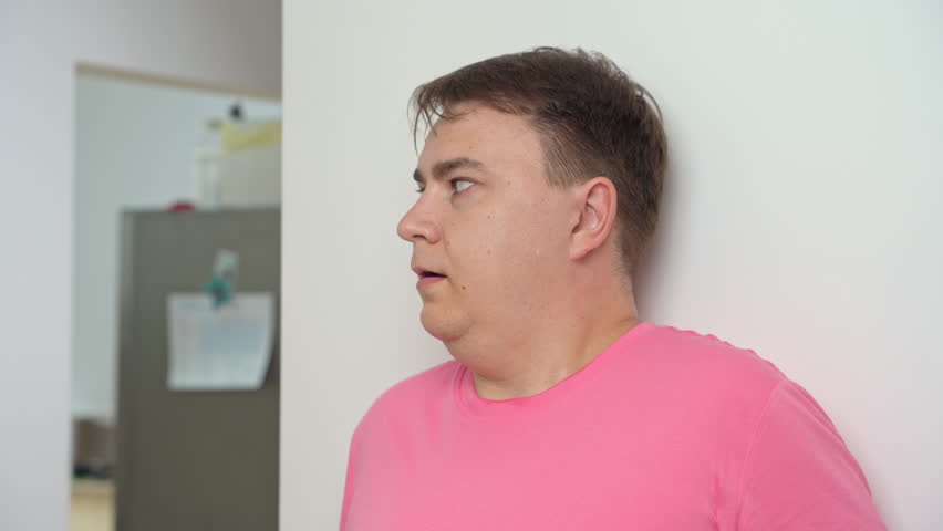 Man looks around corner of room and hides behind wall breathing heavily. Shocked mature man sees danger trying to hide behind wall to be safe | Shutterstock HD Video #1111801029
