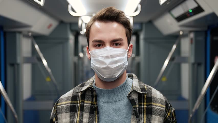 Portrait of a young man in medical mask rides the subway, student goes to study at the university, morning on the public transport, health protection. | Shutterstock HD Video #1111808461