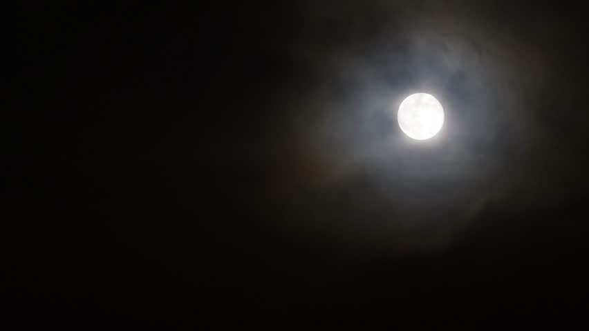 the moon plays hide and seek with the clouds at night - windy