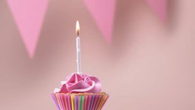 Blowing out a burning candle on a birthday cupcake. Concept of celebration birthday. Video 4k.