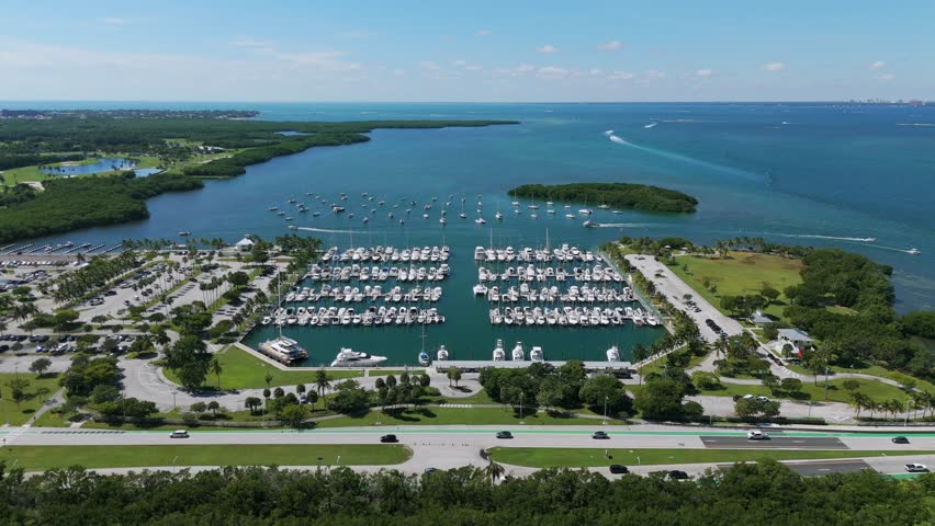 Aerial view of luxury yacht club in tropical resort near Key Biscayne. Lots of exclusive white boats docked in sunny Crandon Marina next to parking zone | Shutterstock HD Video #1111820527