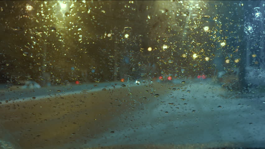 View of road through windshield of car with many drops of rain or snow on it | Shutterstock HD Video #1111821623