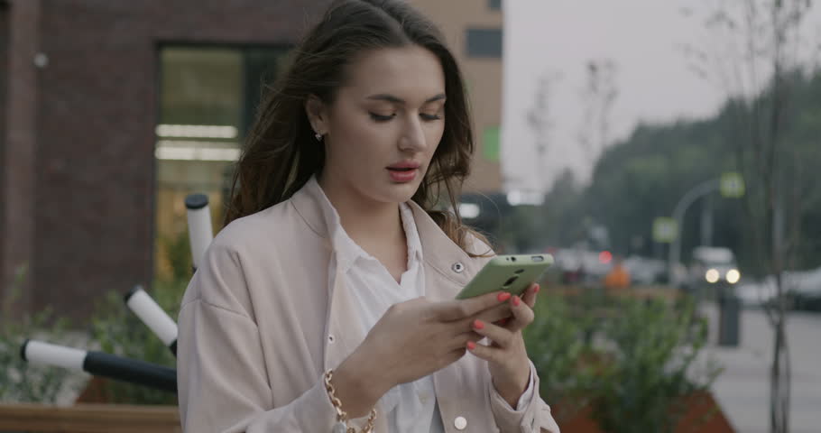 Slow motion of businesswoman recording audio message using smartphone standing in city street. Business communication and technology concept. | Shutterstock HD Video #1111822041