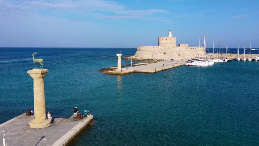 Mandraki port with deers statue, where The Colossus was standing and fort of St. Nicholas. Rhodes, Greece. Hirschkuh statue in the place of the Colossus of Rhodes, Rhodes, Greece