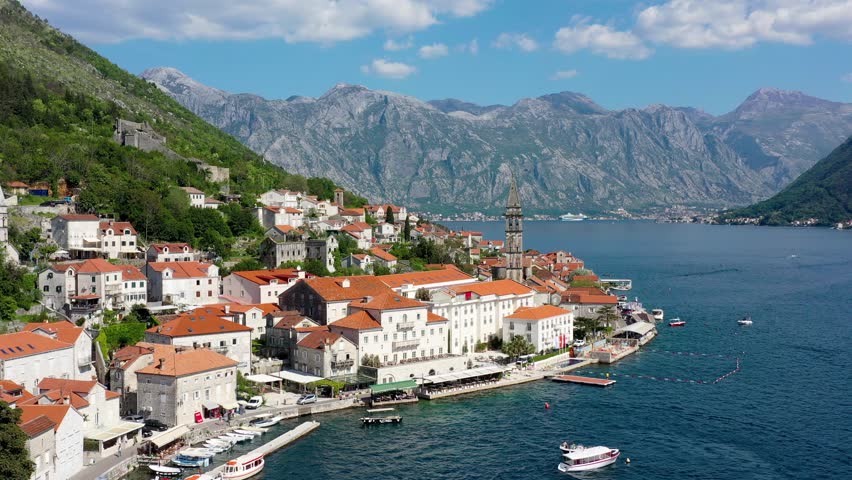View of the historic town of Perast at famous Bay of Kotor on a beautiful sunny day with blue sky and clouds in summer, Montenegro. Historic city of Perast at Bay of Kotor in summer, Montenegro. Royalty-Free Stock Footage #1111823977