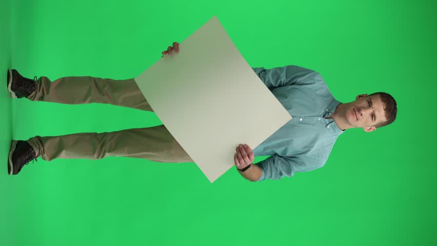man on a green background in full growth holding a white sheet of paper copy spice