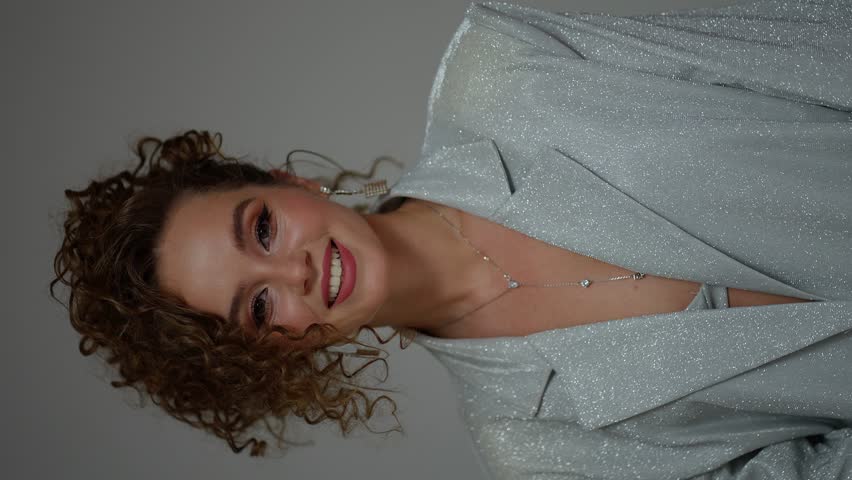 Female beauty in silver clothes poses for the camera
