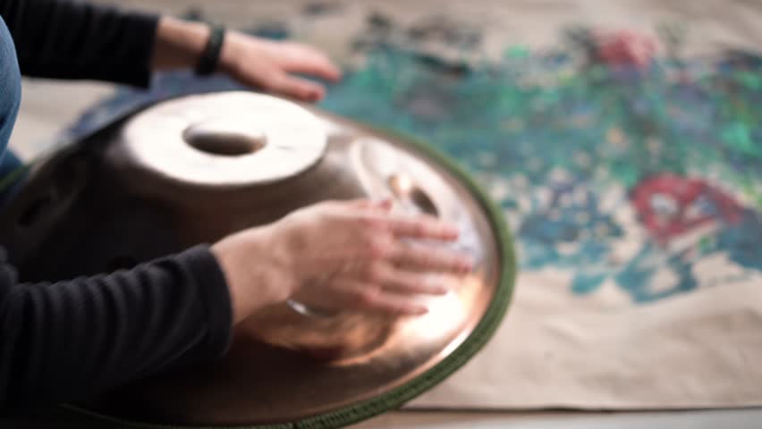 Hands with hang drum close up, man practicing meditation music 