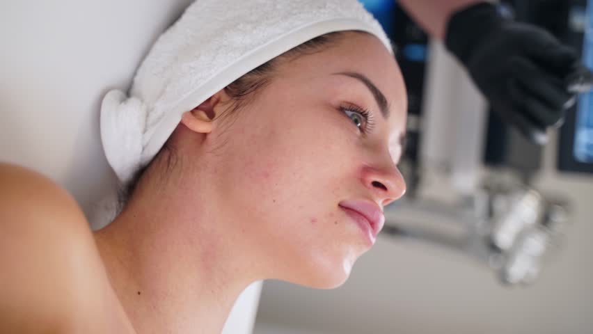 Client receives hydra dermabrasion treatment for skin rejuvenation at spa. Esthetician performs non-invasive exfoliation, clears pores, hydrates, enhances complexion using water peeling device. | Shutterstock HD Video #1111830239