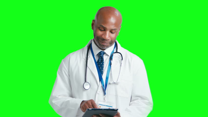 Studio portrait of mature male doctor wearing white coat holding digital tablet against green screen - shot in slow motion | Shutterstock HD Video #1111830521